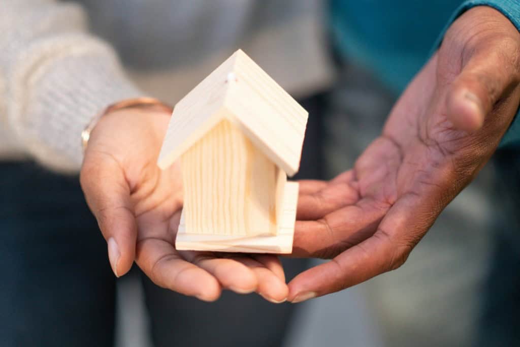two hands holding a wooden house Mortgage down payment gift rules