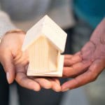 two hands holding a wooden house Mortgage down payment gift rules