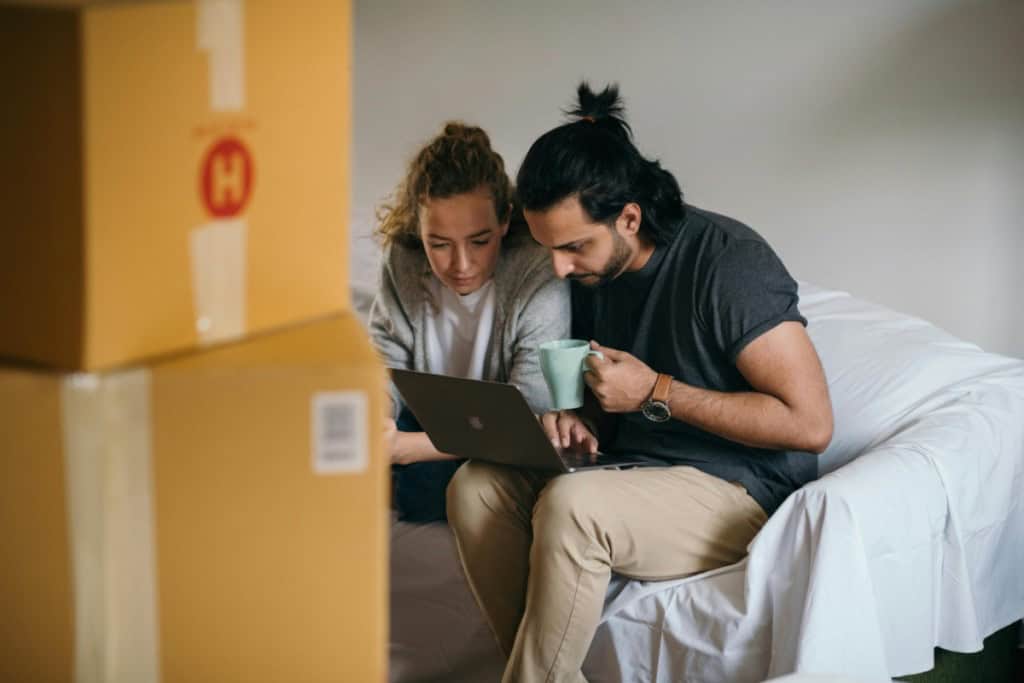 couple looking over a computer at an offfer for their home making sure there are no red flags in an offer